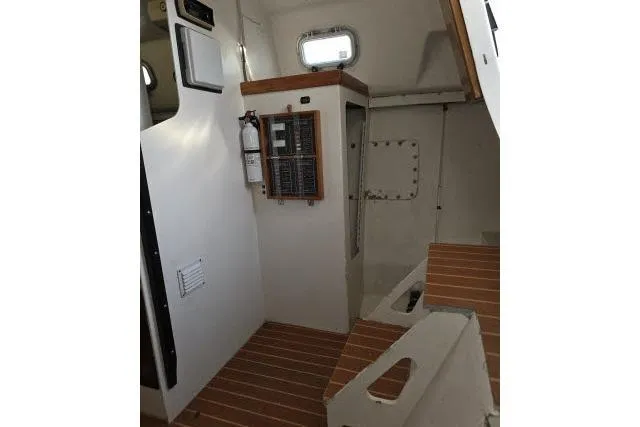 Slide: The Image of Interior of 1986 Bill Lee Yachts Santa Cruz 50, featuring control panel and wooden flooring. - 32