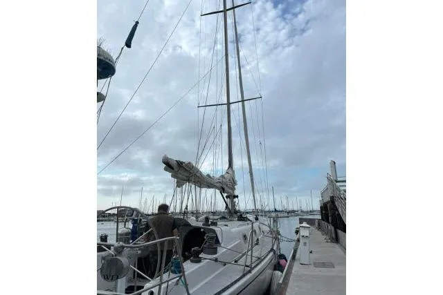 Slide: The Image of 1986 Bill Lee Yachts Santa Cruz 50 sailboat docked at marina under cloudy sky. - 36