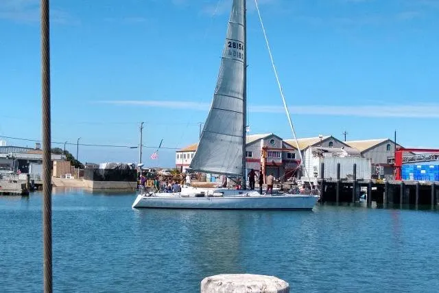 Slide: The Image of 1986 Bill Lee Yachts Santa Cruz 50 sailboat docked in a marina under clear blue skies. - 37
