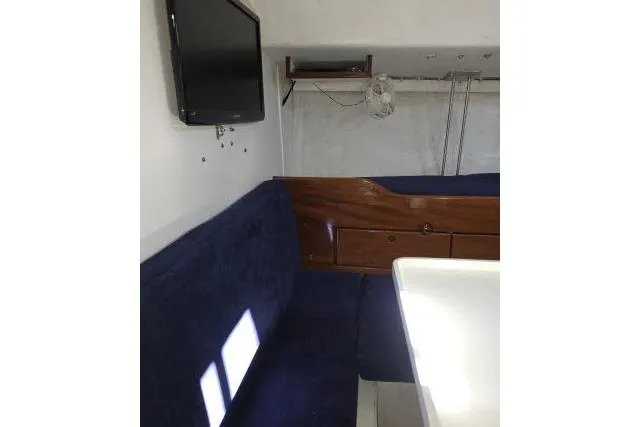 Slide: The Image of Interior of 1986 Bill Lee Yachts Santa Cruz 50 with seating, table, and mounted TV. - 7
