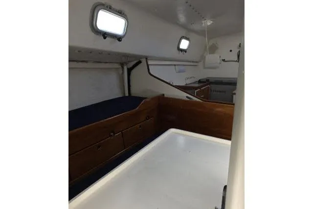 Slide: The Image of Interior of 1986 Bill Lee Yachts Santa Cruz 50, featuring wooden cabinetry and portholes. - 8
