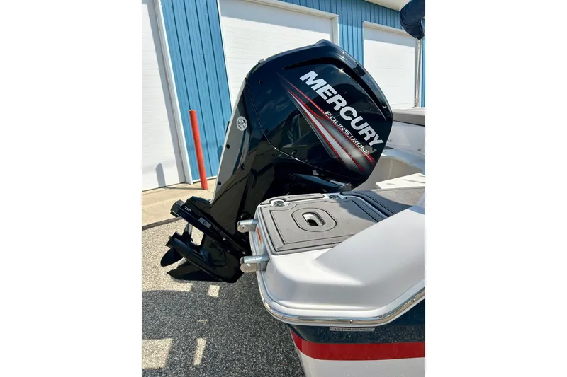 Slide: The Image of 2017 Four Winns 180 Horizon with Mercury FourStroke outboard engine, parked near blue building. - 12