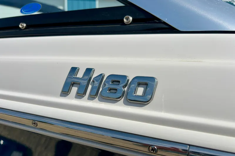 Slide: The Image of Chrome "H180" emblem on a 2017 Four Winns 180 Horizon boat exterior. - 16