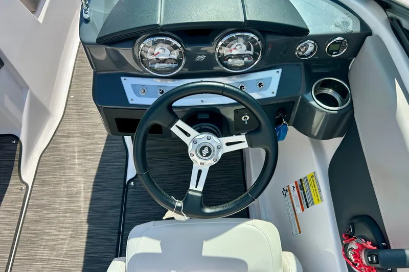 Slide: The Image of Steering wheel and dashboard of 2017 Four Winns 180 Horizon boat, featuring gauges and controls. - 28
