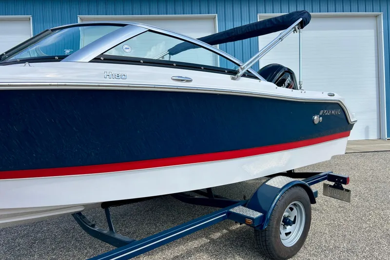 Slide: The Image of 2017 Four Winns 180 Horizon boat on trailer, blue and white with red stripe. - 4