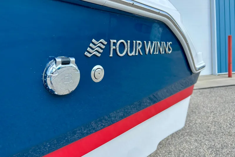 Slide: The Image of 2017 Four Winns 180 Horizon boat, blue hull with red stripe, docked near a building. - 44