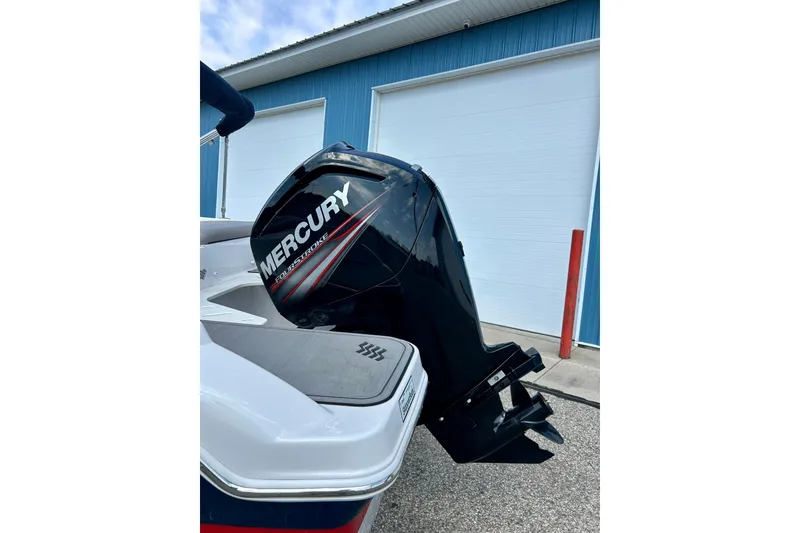 Slide: The Image of 2017 Four Winns 180 Horizon with Mercury FourStroke outboard motor, parked near a blue building. - 46