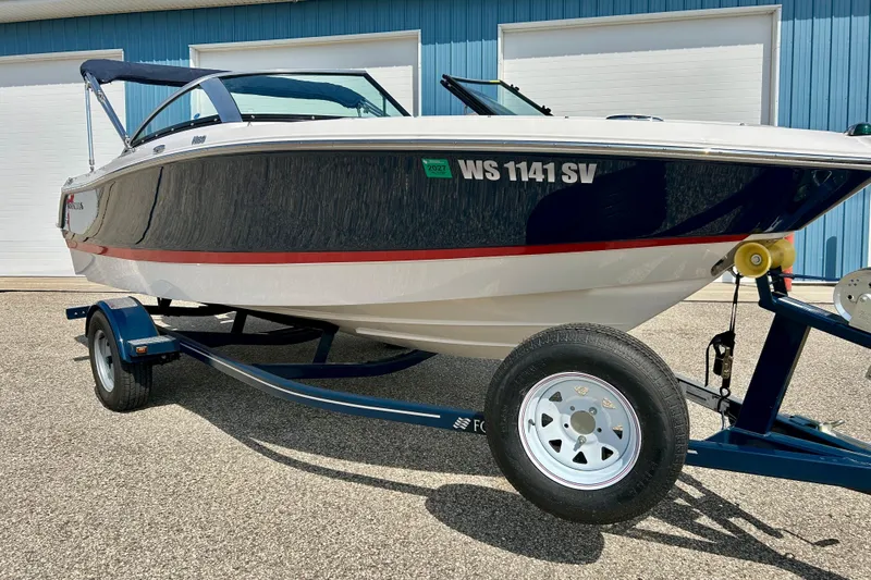 Slide: The Image of 2017 Four Winns 180 Horizon boat on trailer, parked outside a blue building. - 5