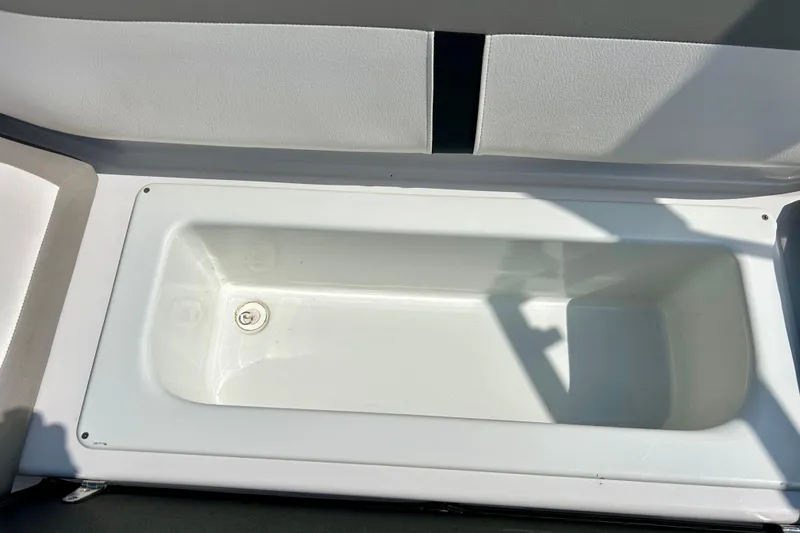Slide: The Image of Storage compartment in a 2017 Four Winns 180 Horizon boat, featuring a clean white interior. - 52