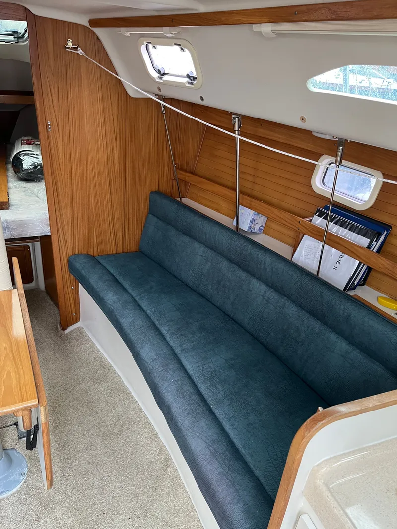 Slide: The Image of Interior of a 2000 Catalina 28 MkII yacht with blue cushioned seating. - 13