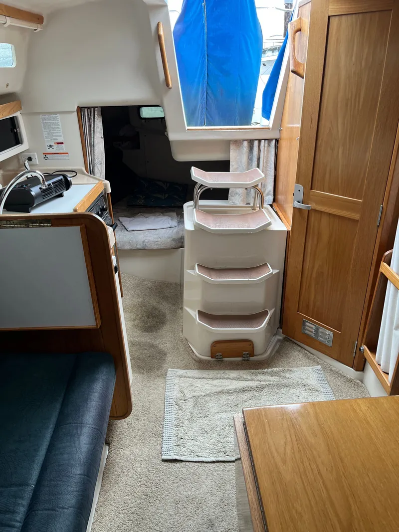 Slide: The Image of Interior of a 2000 Catalina 28 MkII yacht with stairs and wooden furnishings. - 16