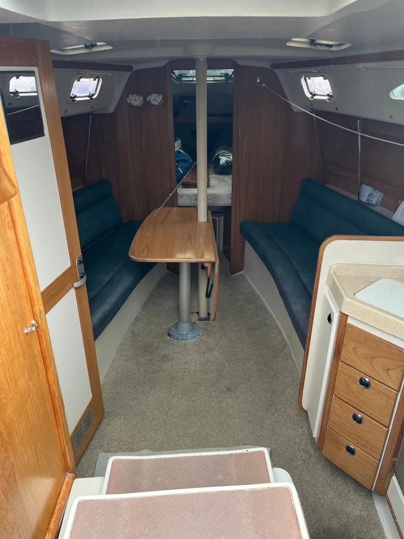 Slide: The Image of Interior of a 2000 Catalina 28 MkII yacht with seating area and table. - 6