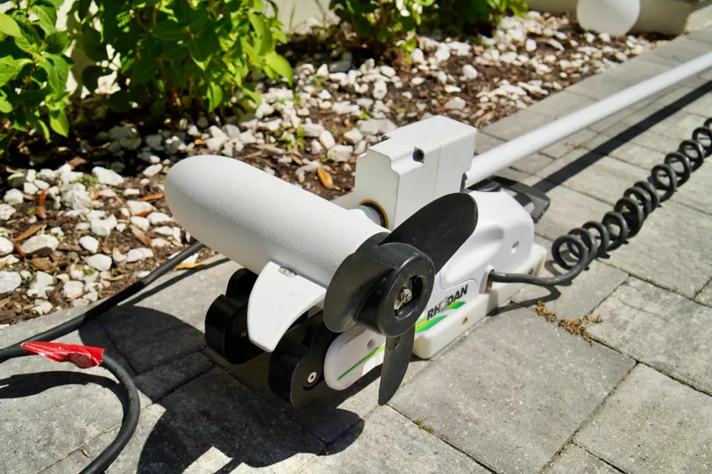 Slide: The Image of Electric trolling motor on pavement, surrounded by greenery. - 10