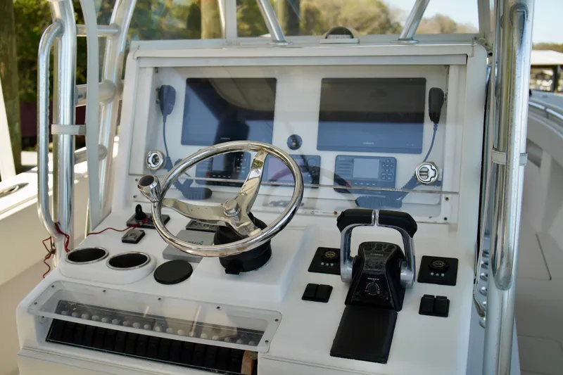 Slide: The Image of 2019 Invincible 36 Open Fisherman helm with steering wheel and navigation controls. - 30