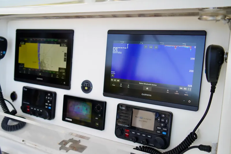 Slide: The Image of 2019 Invincible 36 Open Fisherman dashboard with Garmin navigation displays and communication equipment. - 37