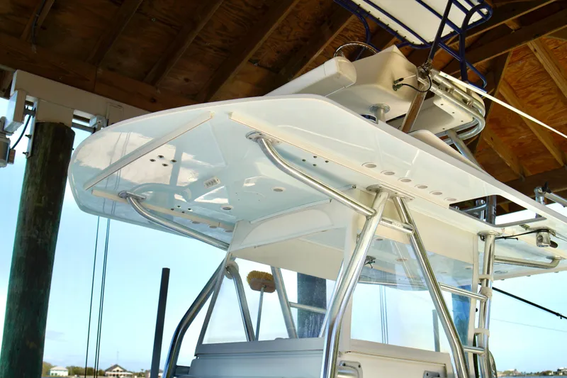 Slide: The Image of 2019 Invincible 36 Open Fisherman boat under a wooden dock, showcasing sleek design and structure. - 48