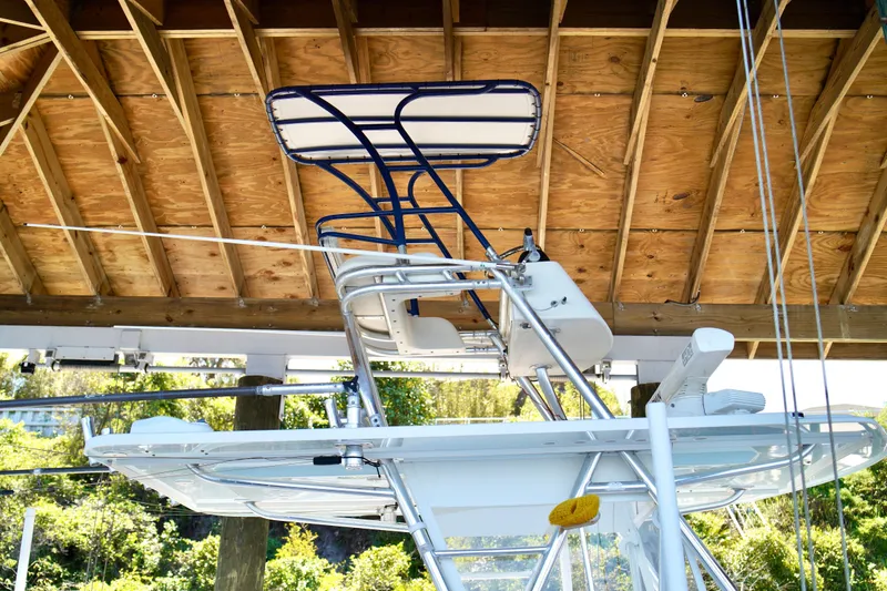 Slide: The Image of 2019 Invincible 36 Open Fisherman boat under wooden dock roof, showcasing tower structure. - 52