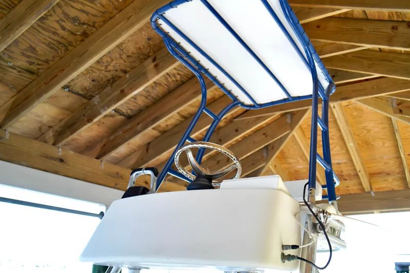 Slide: The Image of 2019 Invincible 36 Open Fisherman boat helm with blue T-top under wooden roof. - 53