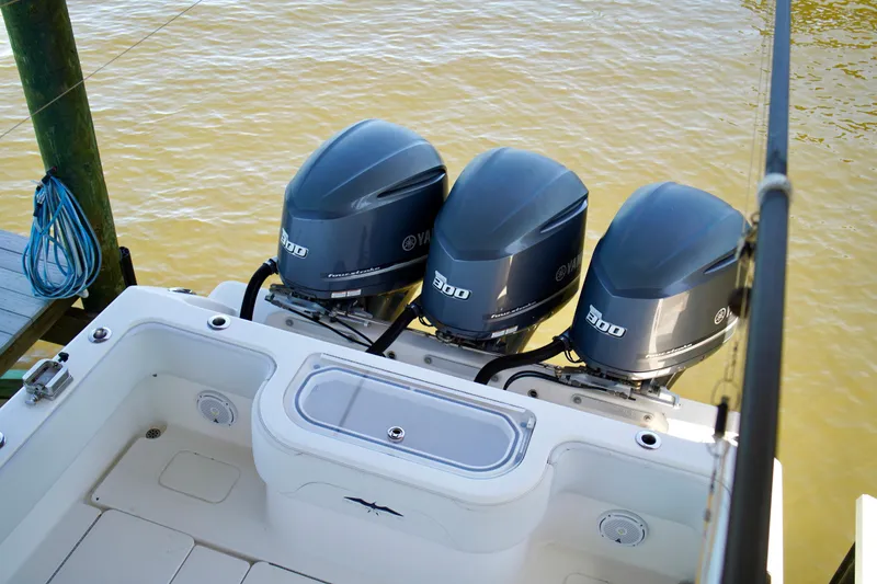 Slide: The Image of 2019 Invincible 36 Open Fisherman with triple Yamaha 300 engines, docked on calm water. - 58