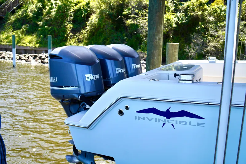 Slide: The Image of 2019 Invincible 36 Open Fisherman with triple Yamaha 300 engines docked by the water. - 65