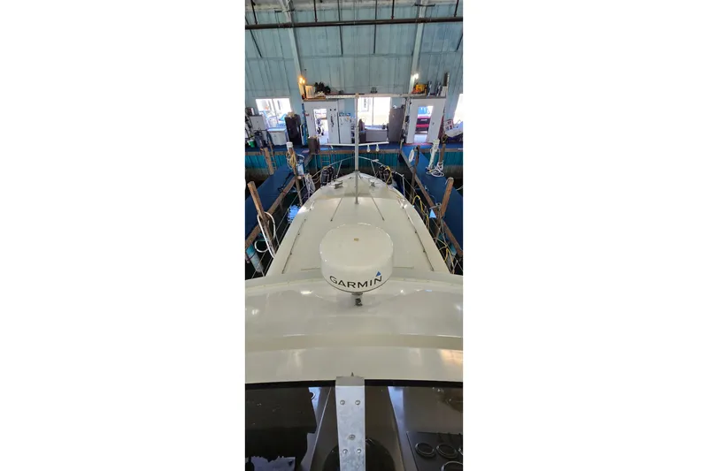 Slide: The Image of 1977 Bertram 42 Flybridge Motor Yacht in a marina, featuring Garmin equipment. - 17