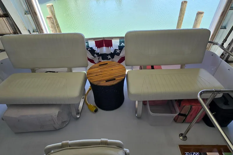 Slide: The Image of 1977 Bertram 42 Flybridge Motor Yacht interior with white seating and wooden table. - 18