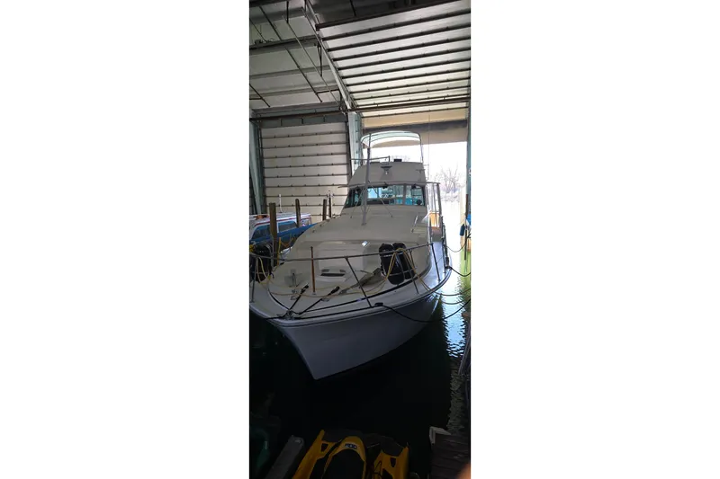 Slide: The Image of 1977 Bertram 42 Flybridge Motor Yacht docked in a covered marina. - 2