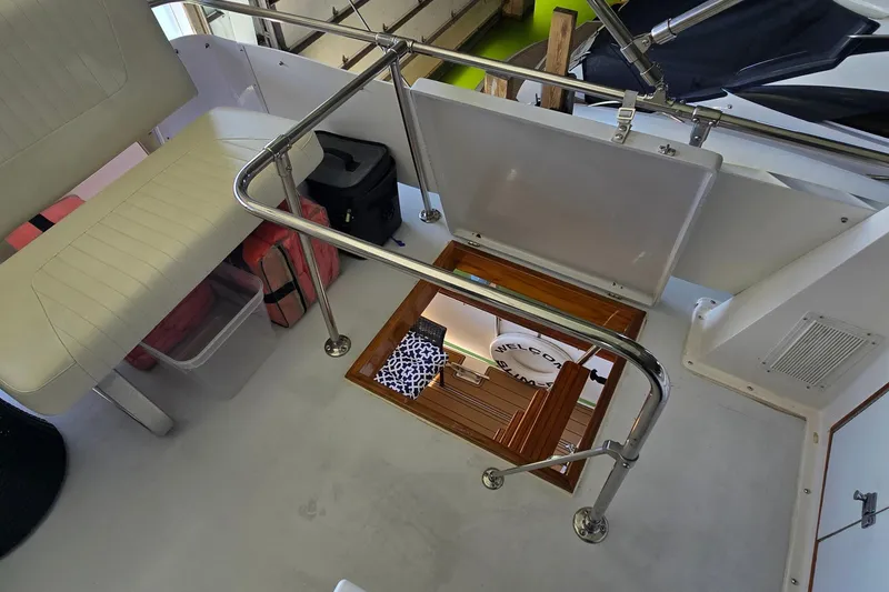 Slide: The Image of 1977 Bertram 42 Flybridge Motor Yacht interior with seating, railing, and open hatch. - 20