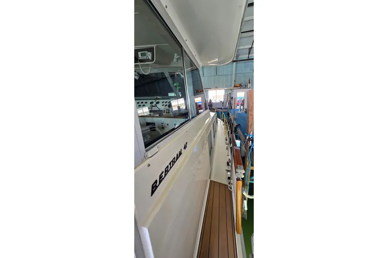 Slide: The Image of 1977 Bertram 42 Flybridge Motor Yacht in a marina, showcasing sleek design and craftsmanship. - 21
