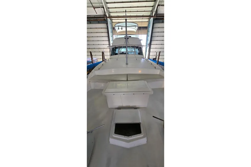 Slide: The Image of 1977 Bertram 42 Flybridge Motor Yacht in a storage facility, viewed from the bow. - 23