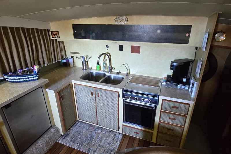 Slide: The Image of 1977 Bertram 42 Flybridge Motor Yacht kitchen with sink, stove, and coffee maker. - 28