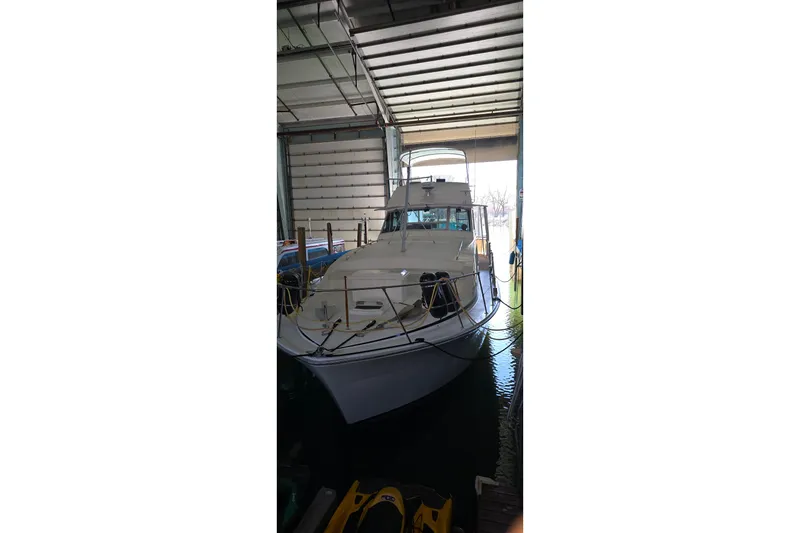 Slide: The Image of 1977 Bertram 42 Flybridge Motor Yacht docked in a covered marina. - 3