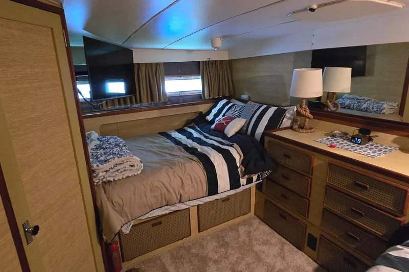 Slide: The Image of Cozy bedroom interior of a 1977 Bertram 42 Flybridge Motor Yacht with striped bedding. - 33
