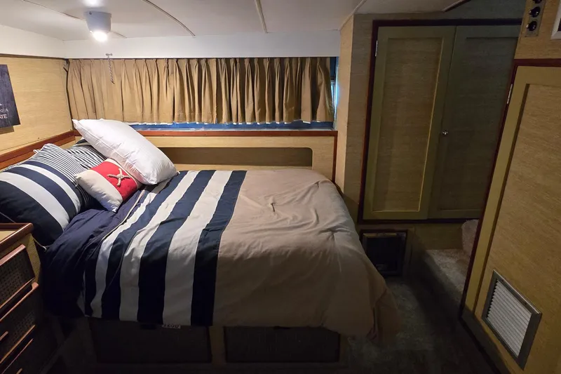 Slide: The Image of Cozy bedroom interior of a 1977 Bertram 42 Flybridge Motor Yacht with striped bedding. - 34