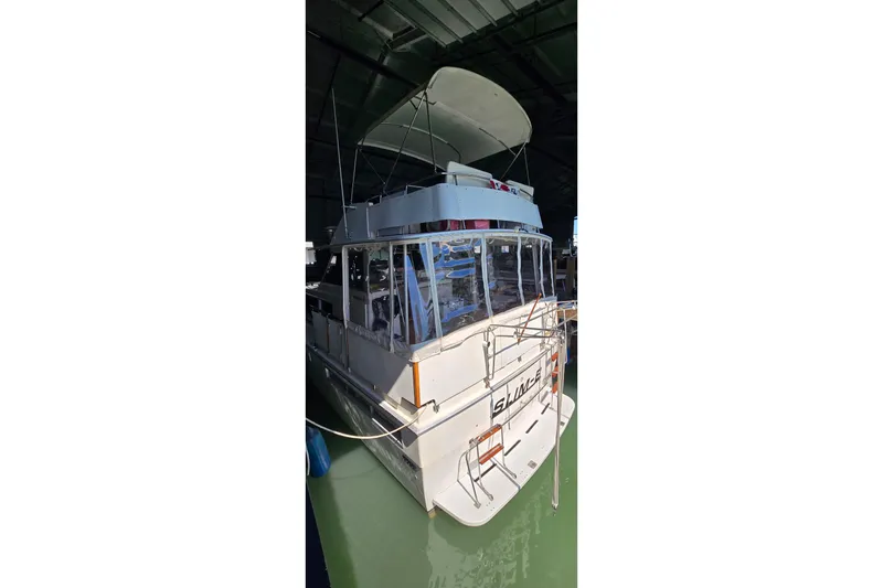 Slide: The Image of 1977 Bertram 42 Flybridge Motor Yacht docked in a covered marina. - 4