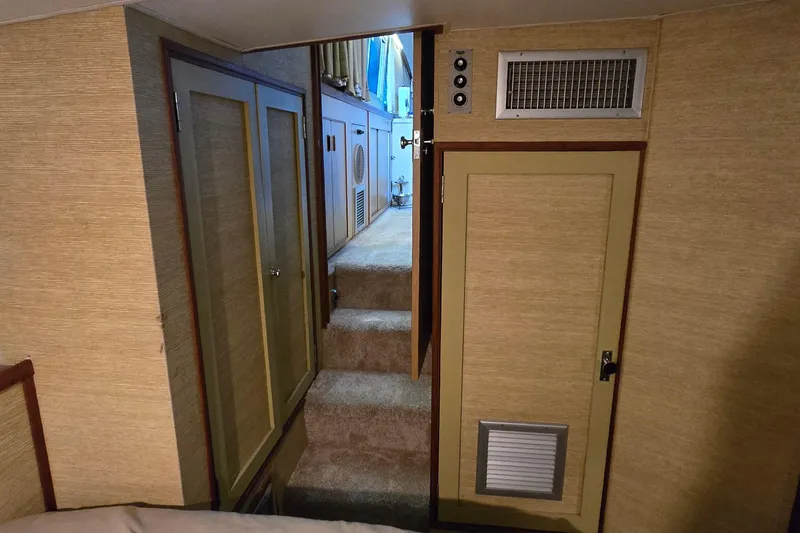 Slide: The Image of Interior of 1977 Bertram 42 Flybridge Motor Yacht with carpeted stairs and wooden cabinetry. - 40
