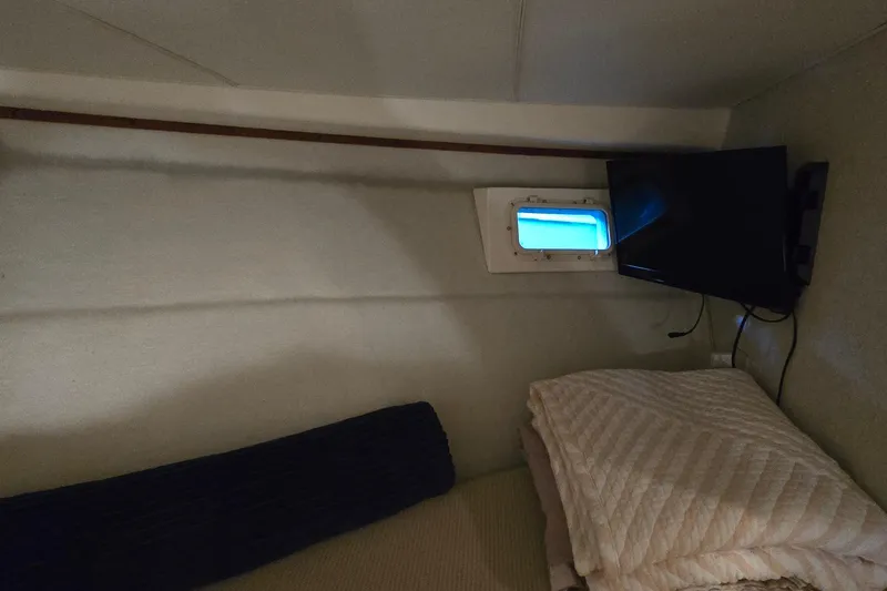 Slide: The Image of Interior cabin of 1977 Bertram 42 Flybridge Motor Yacht with bedding and porthole. - 45