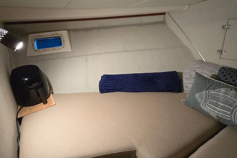 Slide: The Image of Cozy cabin interior of 1977 Bertram 42 Flybridge Motor Yacht with cushions and window. - 46