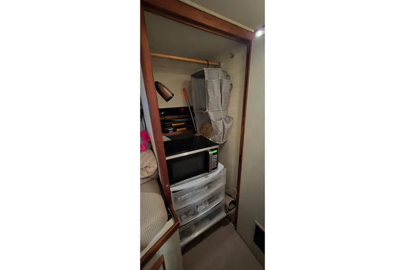 Slide: The Image of 1977 Bertram 42 Flybridge Motor Yacht interior with storage, microwave, and shelving. - 47