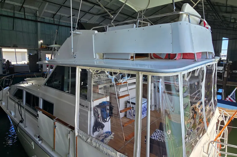 Slide: The Image of 1977 Bertram 42 Flybridge Motor Yacht in a marina, showcasing its classic design. - 5