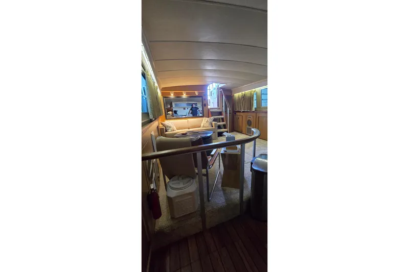 Slide: The Image of Interior of a 1977 Bertram 42 Flybridge Motor Yacht, featuring cozy seating and wooden accents. - 52