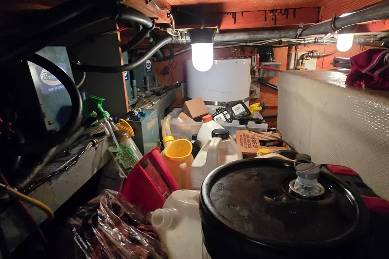 Slide: The Image of Engine room of a 1977 Bertram 42 Flybridge Motor Yacht with various tools and containers. - 61