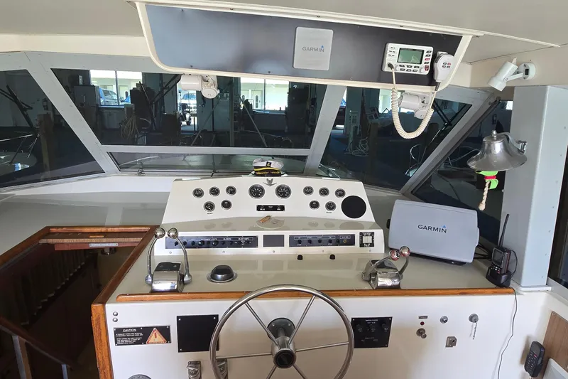 Slide: The Image of 1977 Bertram 42 Flybridge Motor Yacht helm with Garmin navigation equipment and classic controls. - 8
