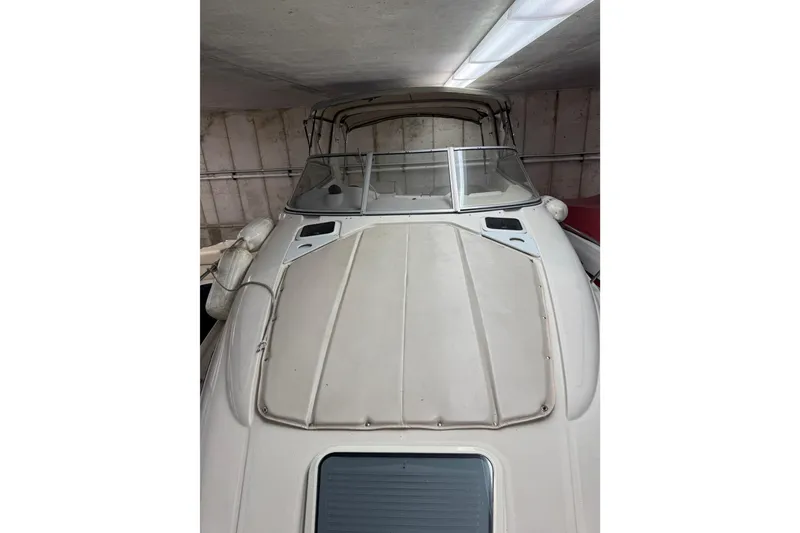 Slide: The Image of 2001 Regal Commodore 2760 boat in storage, featuring a sleek white deck and windshield. - 6
