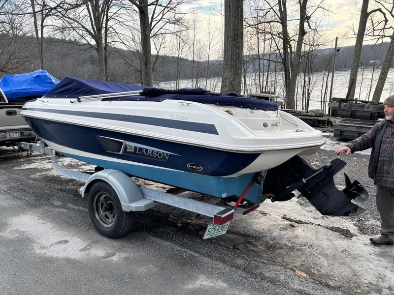 Slide: The Image of 2011 Larson 850 boat on trailer parked outdoors. - 18