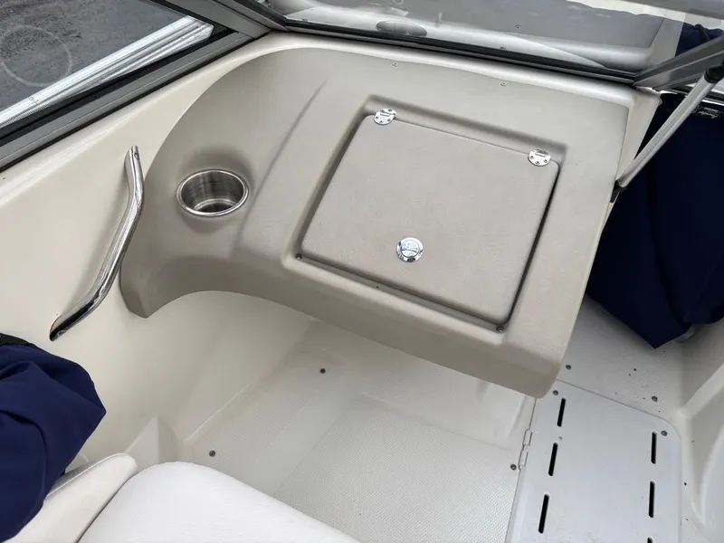 Slide: The Image of Interior of a 2011 Larson 850 boat with storage compartment and cup holder. - 19