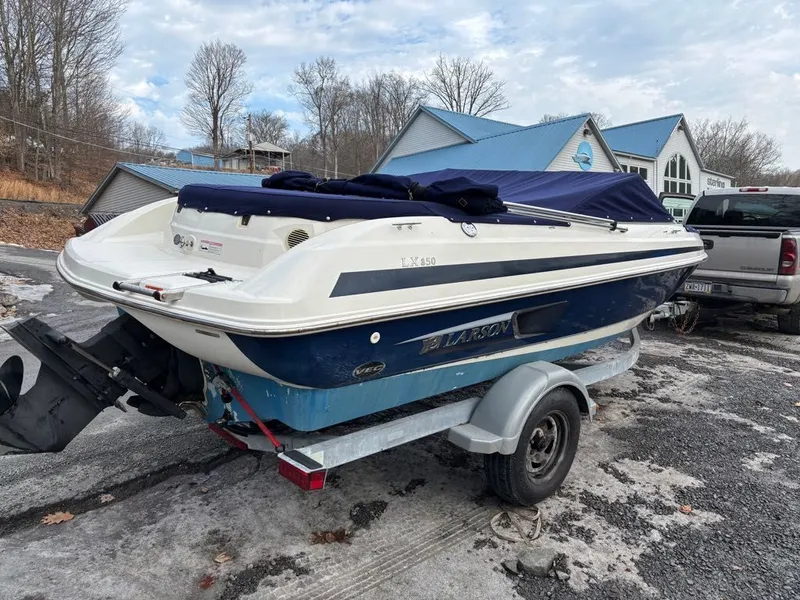 Slide: The Image of 2011 Larson 850 boat parked on trailer outdoors. - 20