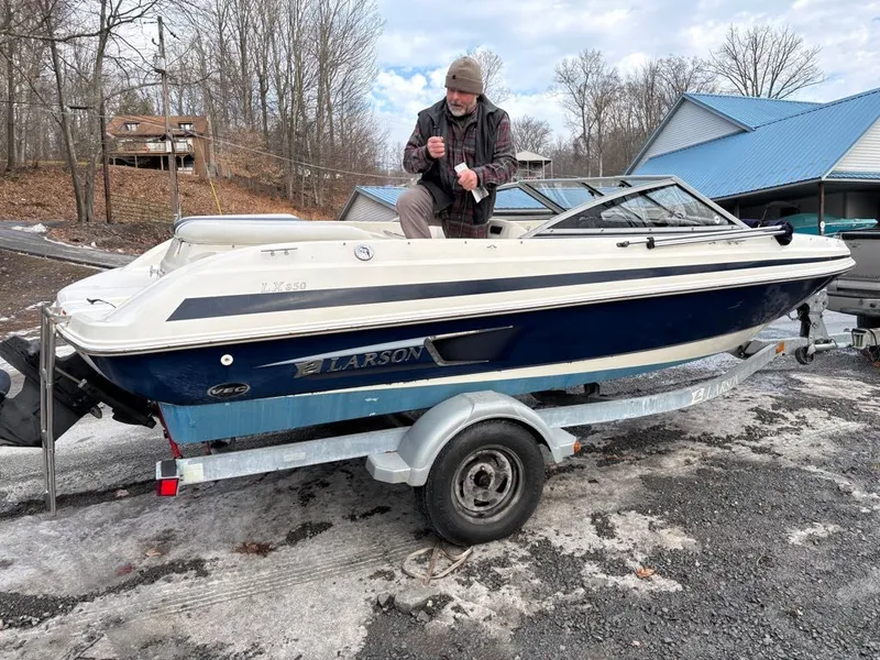 Slide: The Image of Man on 2011 Larson 850 boat on trailer outdoors. - 23