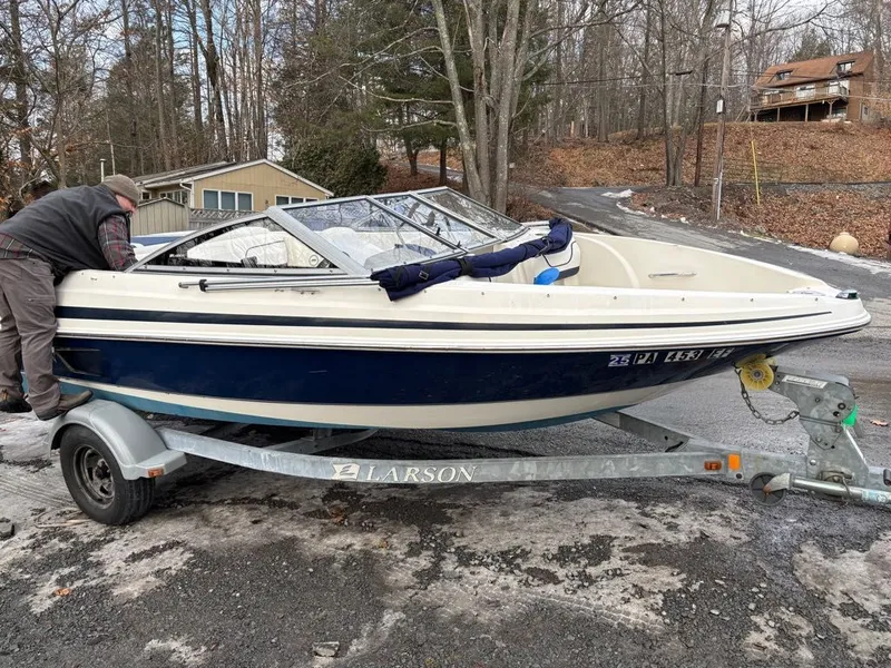 Slide: The Image of 2011 Larson 850 boat parked on trailer outdoors. - 24