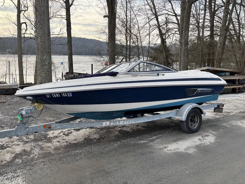Slide: The Image of 2011 Larson 850 boat on trailer by the lake. - 27